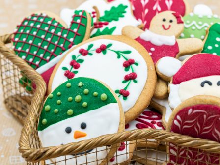 Decorated Christmas gingerbread cookies&mdash;snowmen, trees, and candy canes&mdash;baked in a basket.